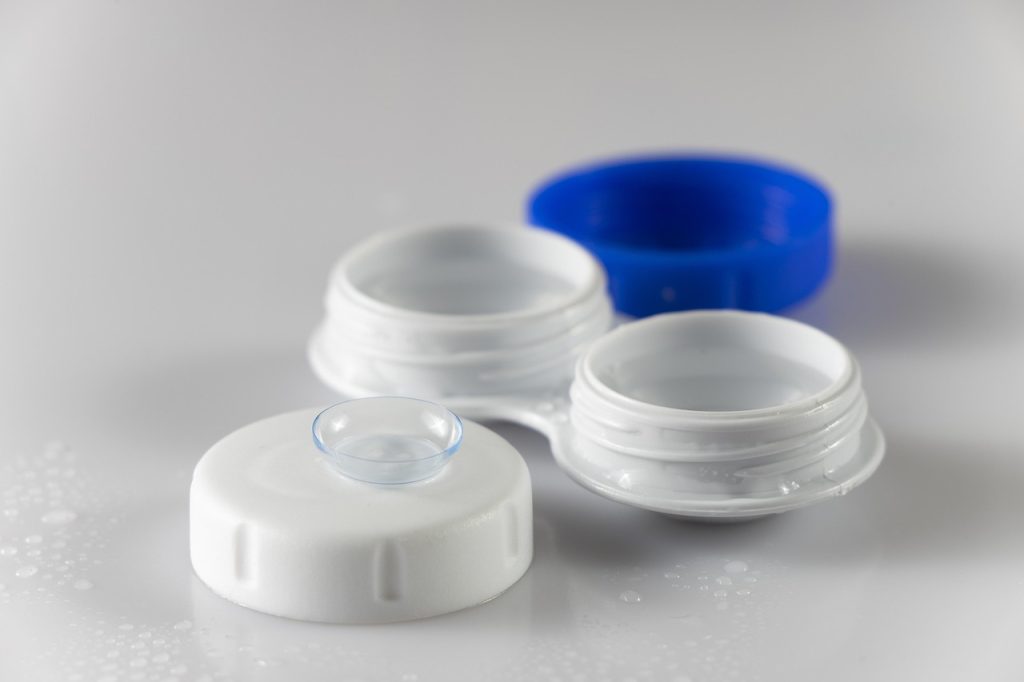 une lentille de contact transparente posée sur une boite de rangement
