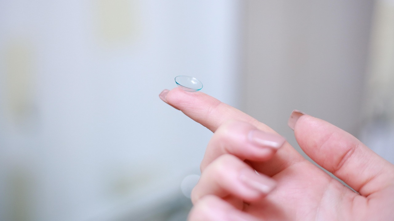 Lentille de contact tenu par un doigt